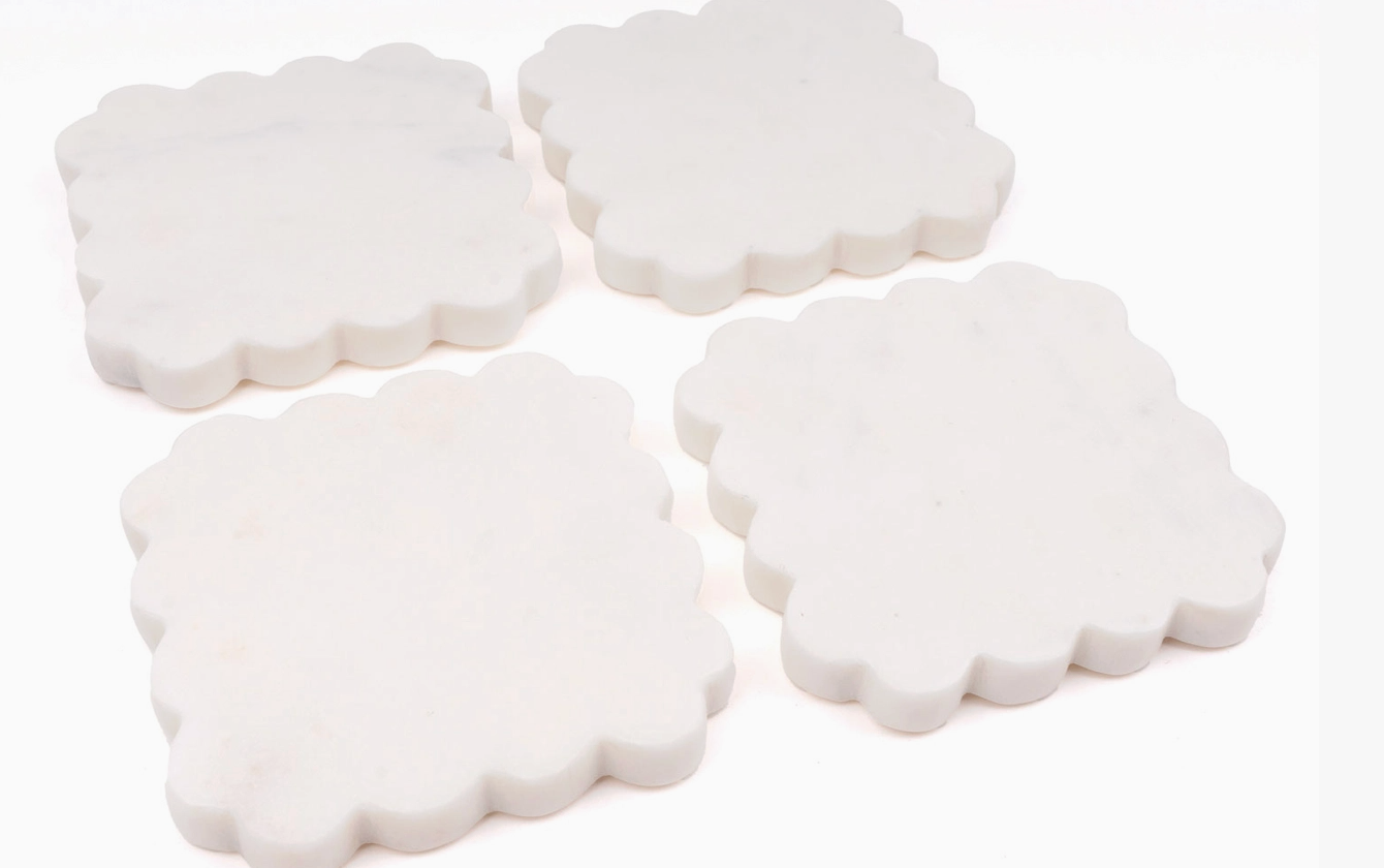 Four 8 Oak Lane brand scalloped marble coasters on white background