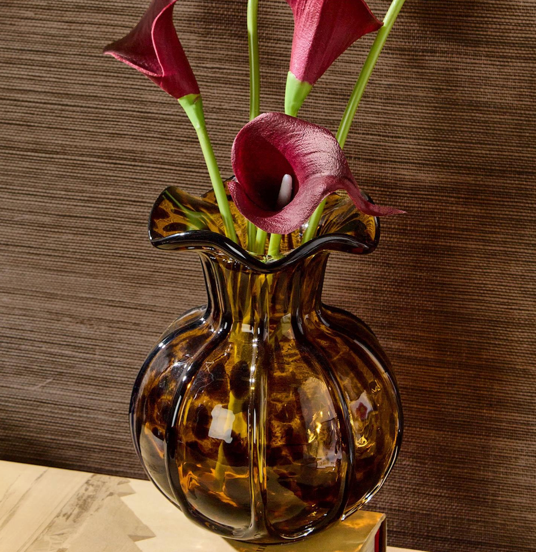 "Ruffled tortoise vase with purple flowers side angle view highlighting sculptural silhouette and warm tortoise tones"