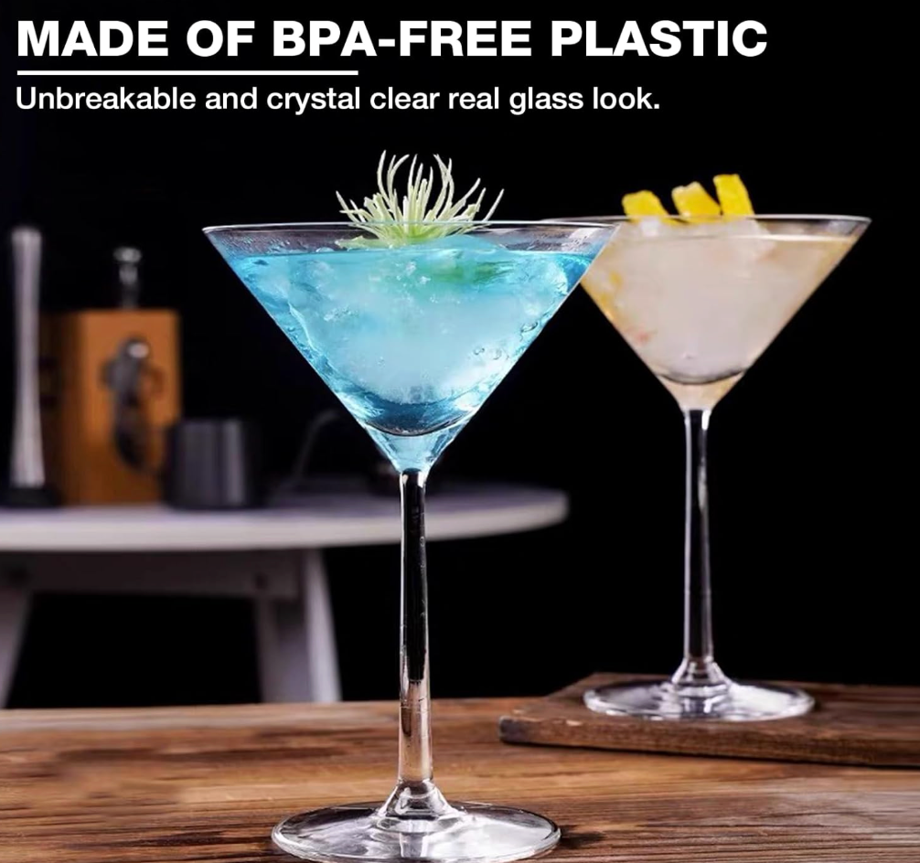 Two clear  Huang Acrylics brand martini glasses filled with cocktails on a wooden table against a dark background, with text at the top reading 'MADE OF BPA-FREE PLASTIC' and 'Unbreakable and crystal clear real glass look.'.