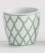 A Napa Home and Garden brand white ceramic cup decorated with a green trellis pattern and a thin green rim, shown against a plain white background.