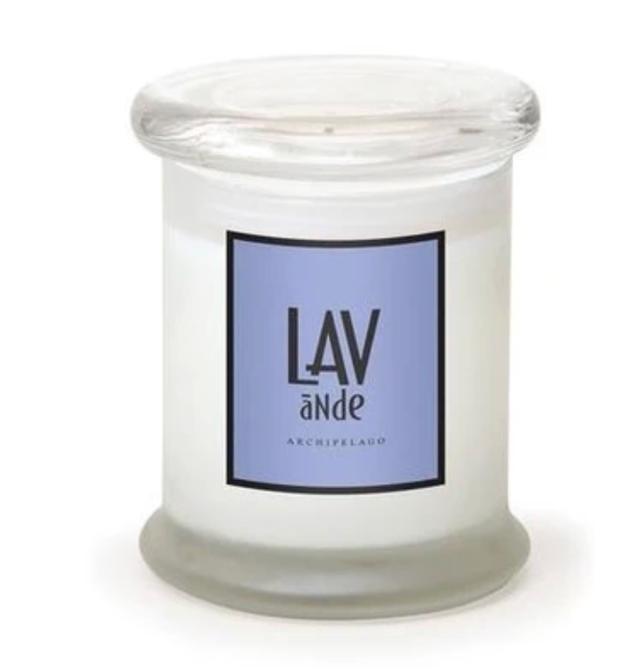 An Archipelago Brand white jar candle with a clear glass lid and base, featuring a lavender-blue label with the text 'LAV aNde' 