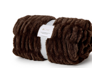 A rolled dark brown faux fur throw blanket with a white paper label that reads 'CHIC', set against a plain white background.