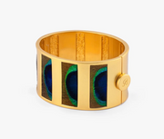 Brackish Natalie matte gold hinged cuff with striped blue and green peacock eye feather panels and a round button closure”