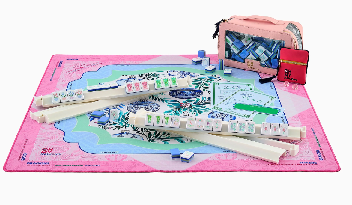 Oh My Mahjong Merriment Christmas mat set up with ivory tile racks, mahjong tiles, reference cards, and a pink tile bag.