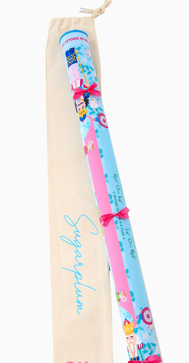 Oh My Mahjong Sugarplum mat rolled with pink ribbon ties beside its cream canvas drawstring storage bag.