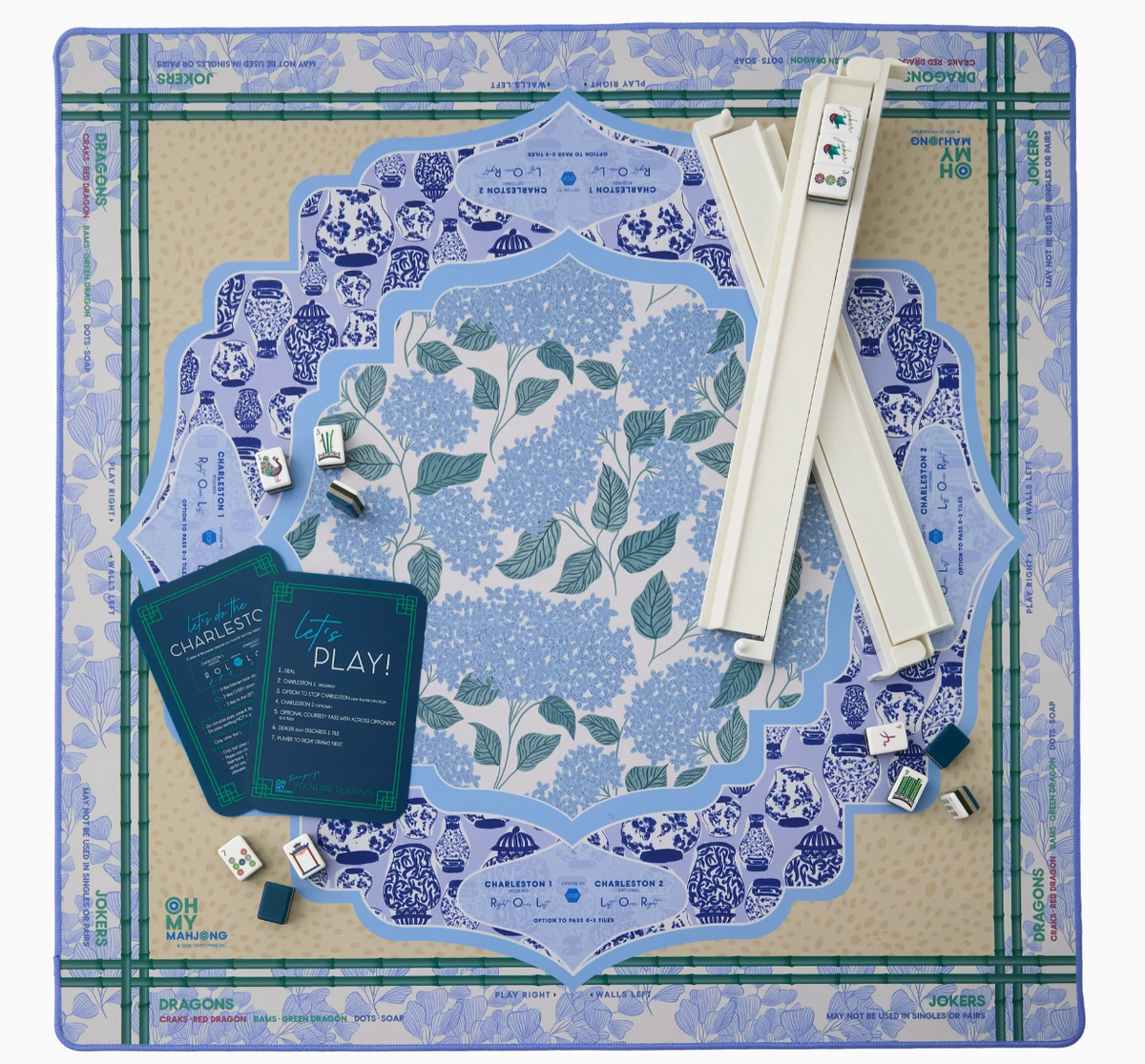 Overhead view of the Oh My Mahjong Luna hydrangea mat with ivory racks, scattered tiles, and navy reference cards.