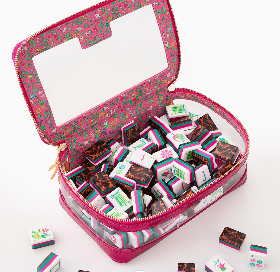 Glow Wild mahjong tiles inside an open pink zippered storage case with floral lining and clear sides.