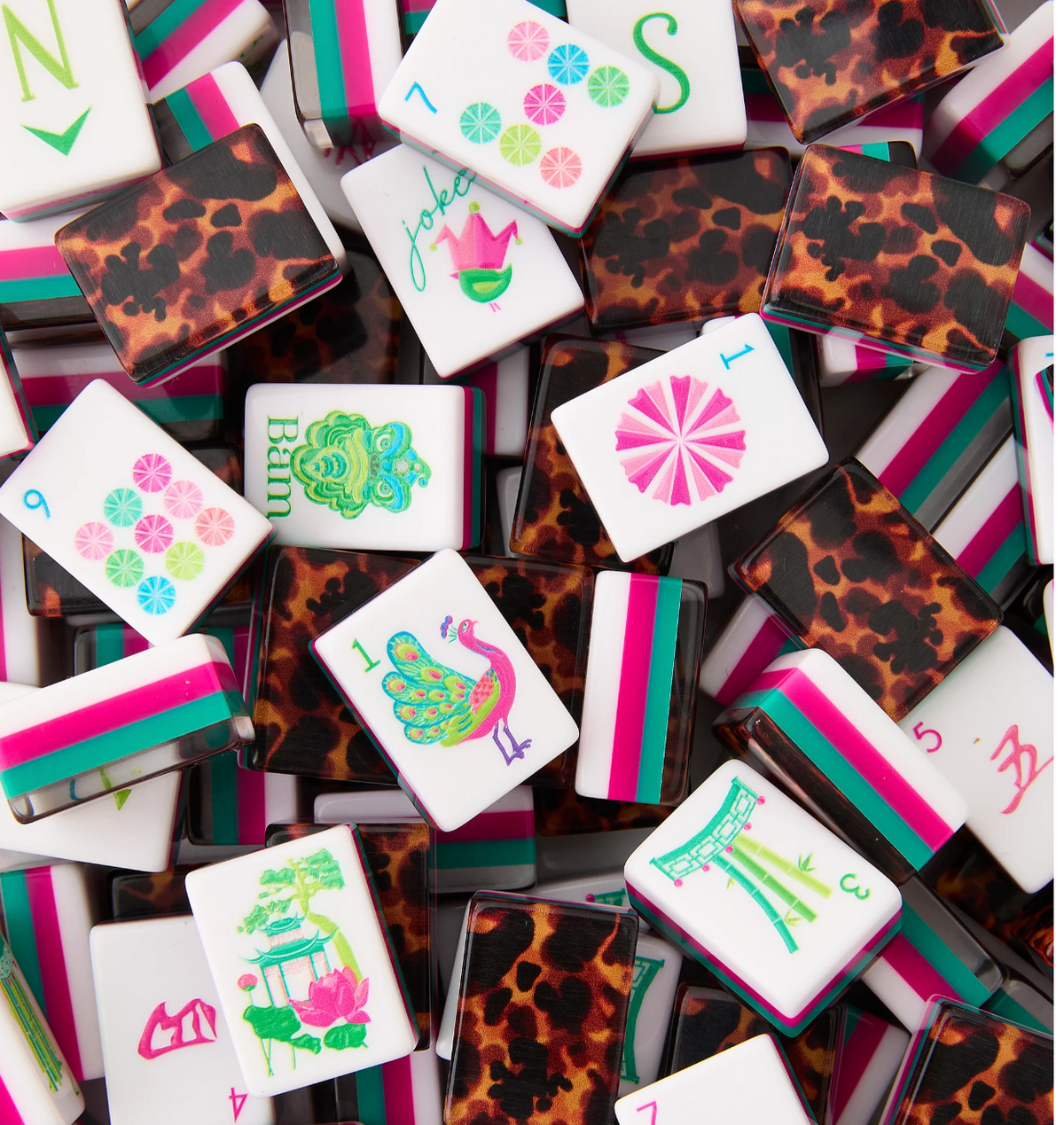 Glow Wild mahjong tiles with colorful illustrated white faces, pink and teal edges, and tortoiseshell-pattern backs.