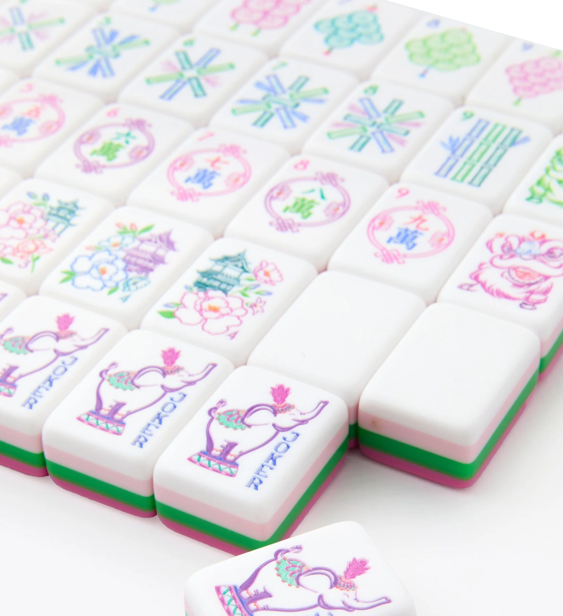Close-up of Oh My Mahjong Amara tiles with elephant Jokers, floral pagodas, and pink and green layered edges.