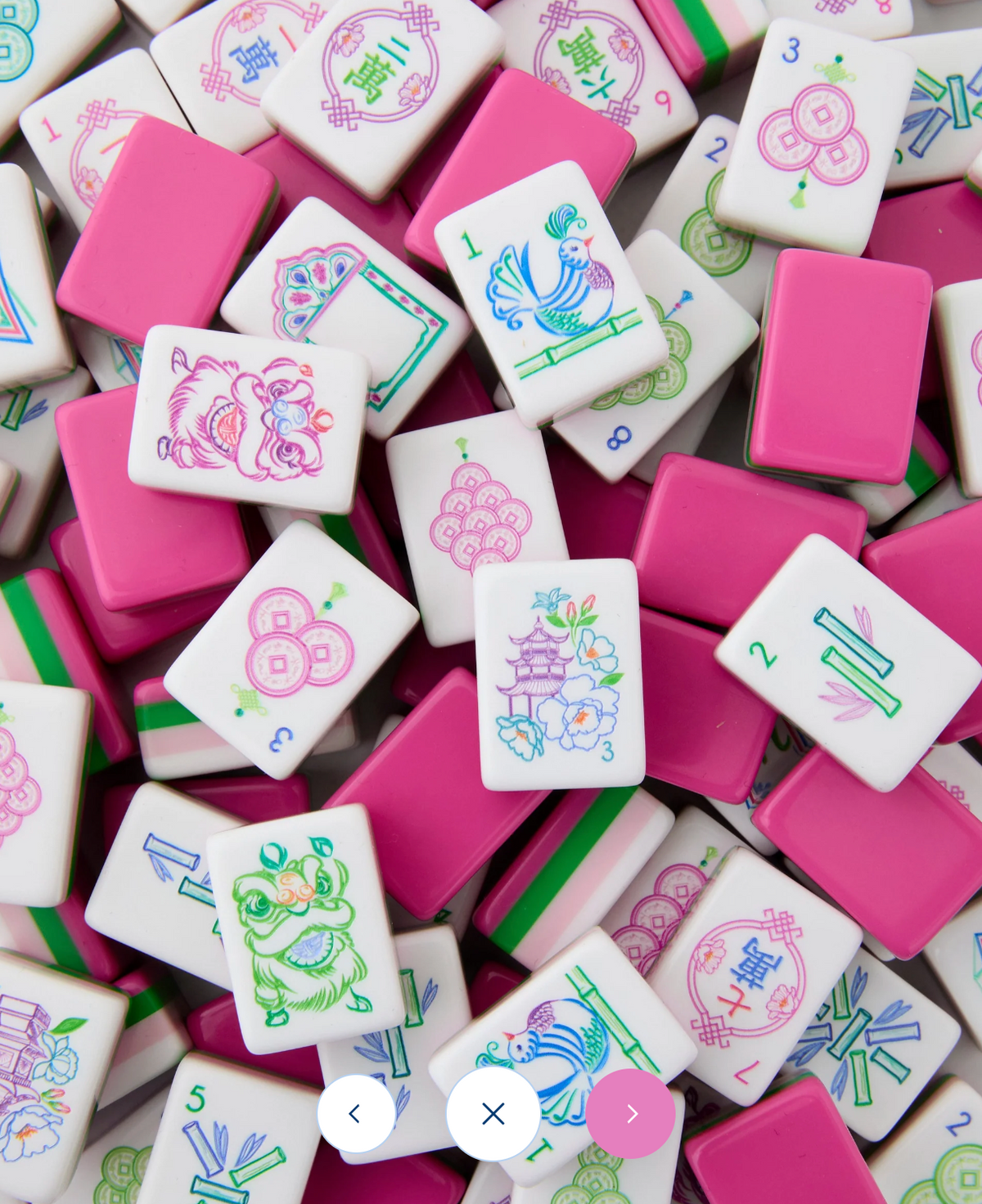 Scattered Oh My Mahjong Amara tiles showing bright pink backs, green layers, and illustrated white faces.

