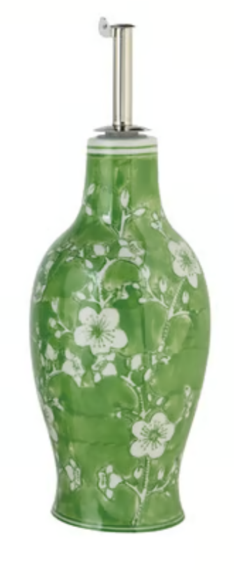 Hand-painted stoneware oil cruet with green-and-white floral pattern, oval body, and stainless steel pour spout.