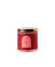 Red candle with a gold lid and pink label on a white background