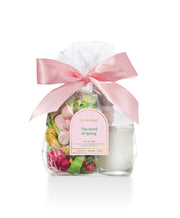 Glass jar with decorative flowers and a pink bow on a white background