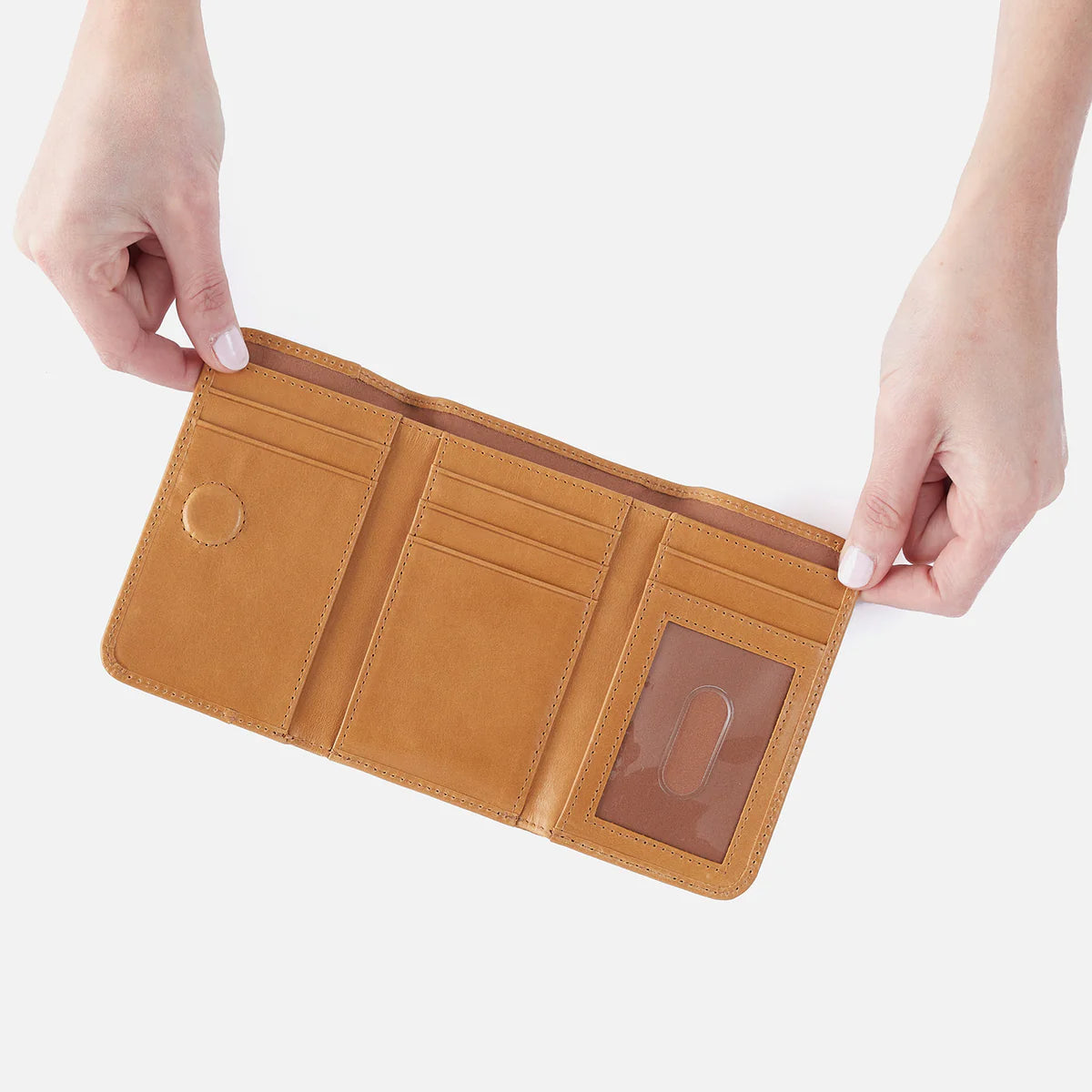 Brown leather wallet held open by hands on a white background