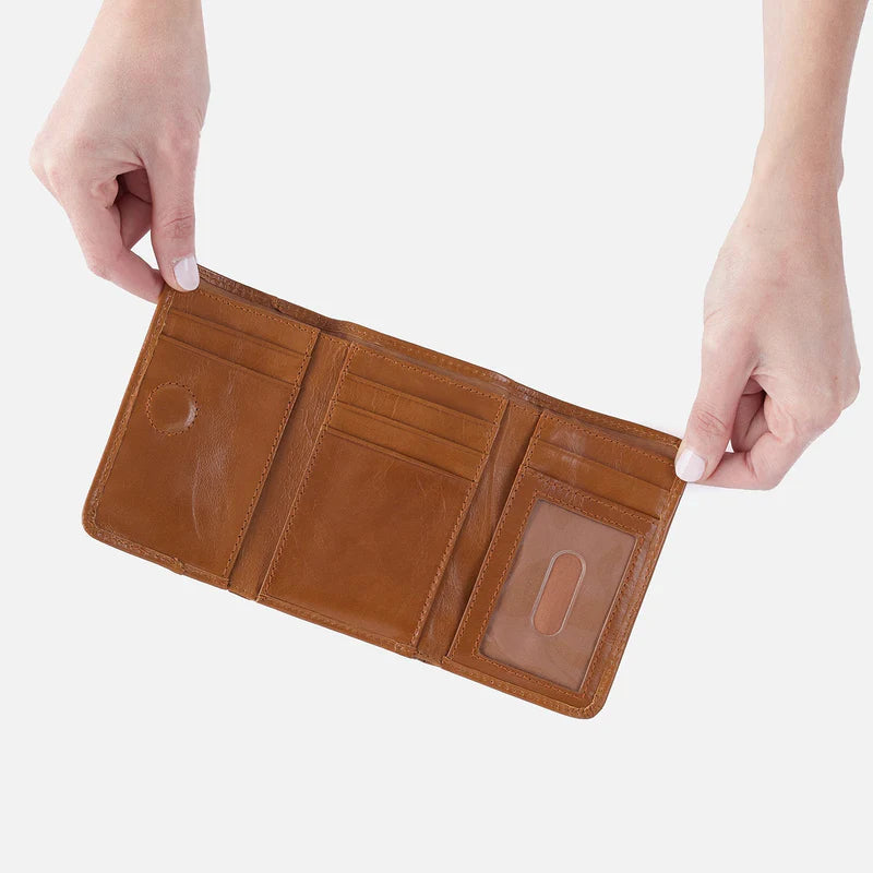 Brown leather wallet held open by hands on a white background