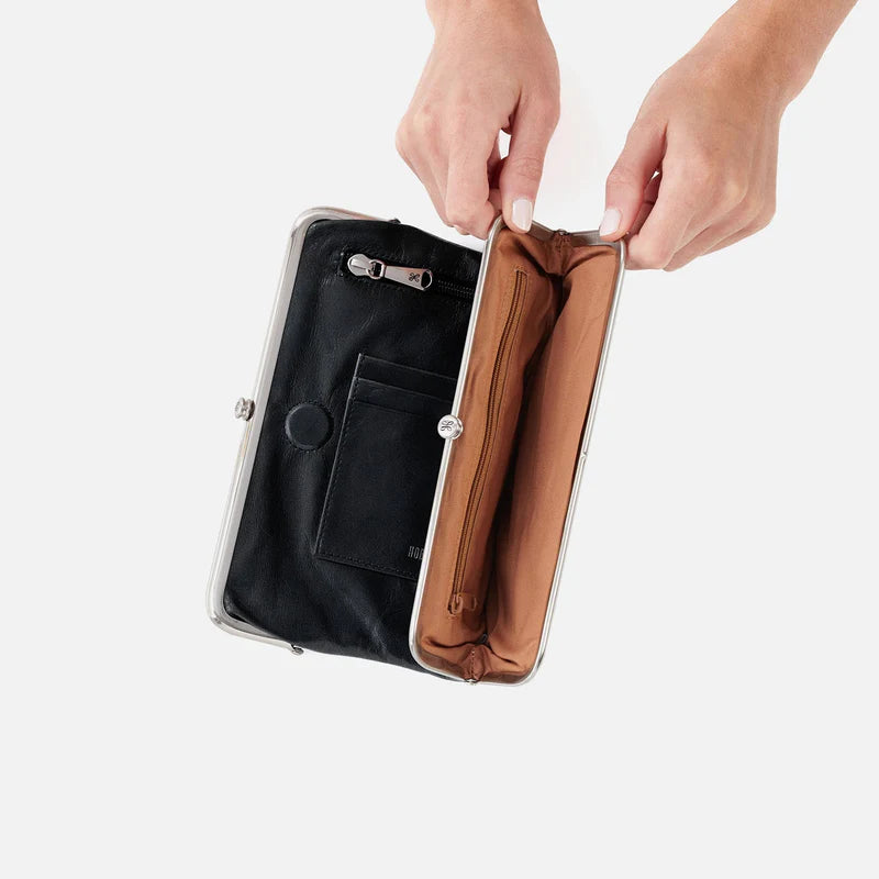 Person opening a black and copper clutch bag on a white background