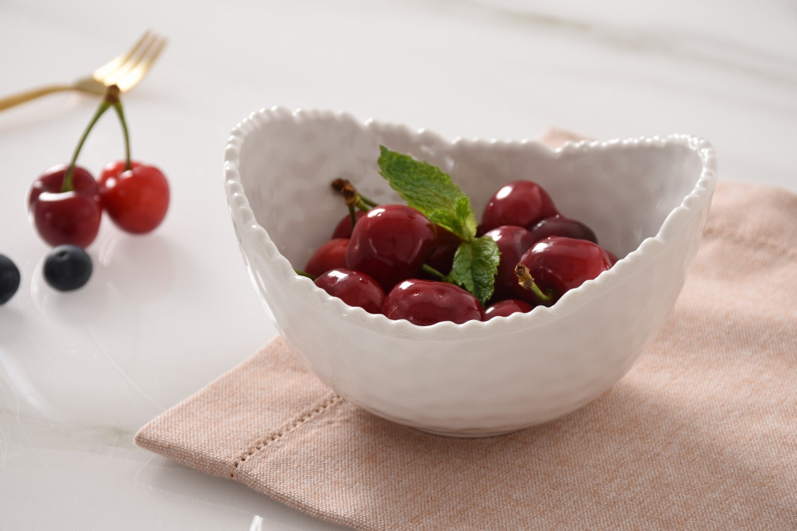 Pampa bay White decorative melamine bowl filled with cherries on a light surface