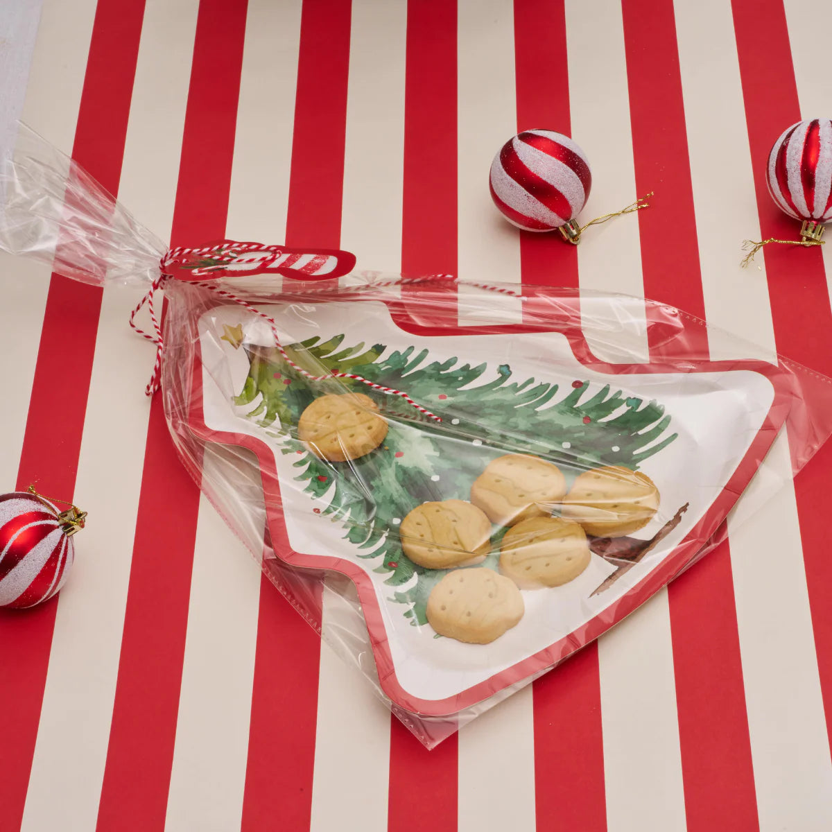 Christmas-themed cookie tray with cookies on a red and white striped background