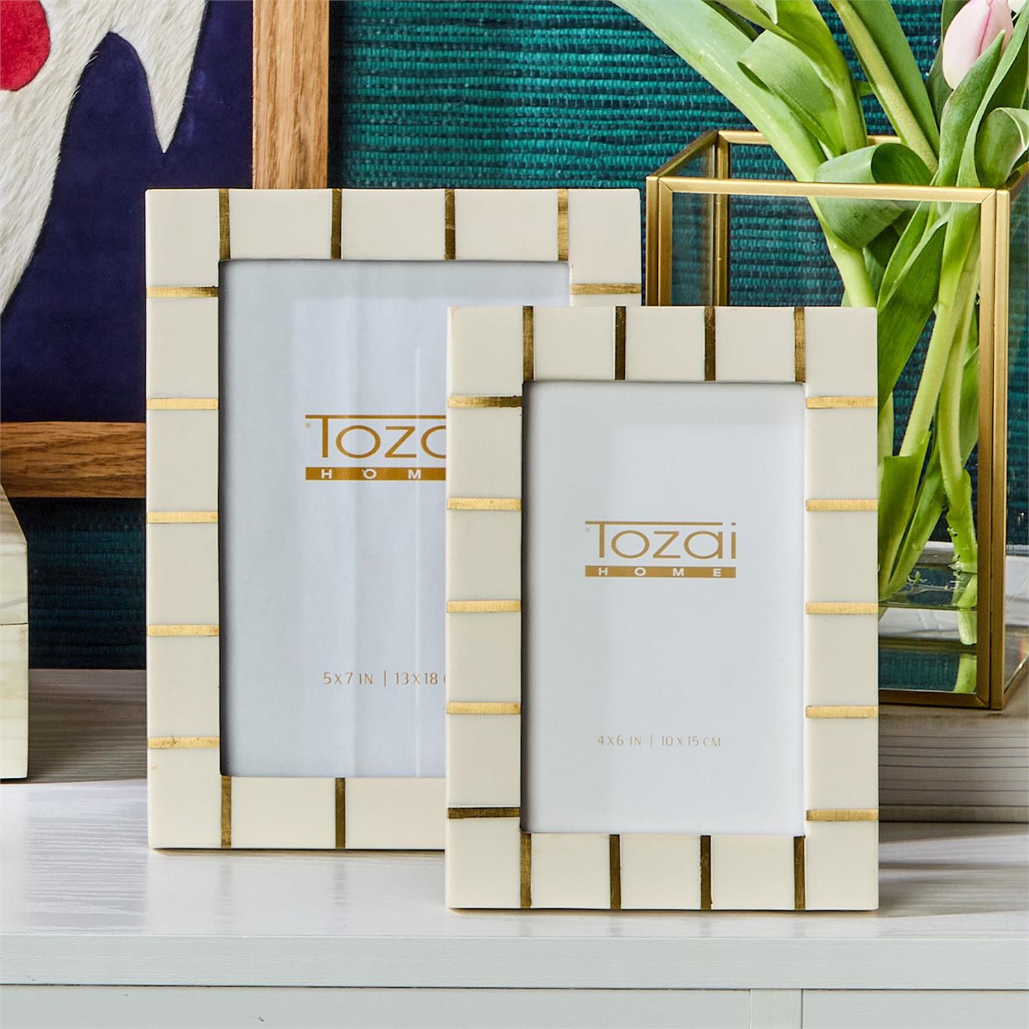 Two decorative picture frames with 'Tozai Home' branding on a surface.