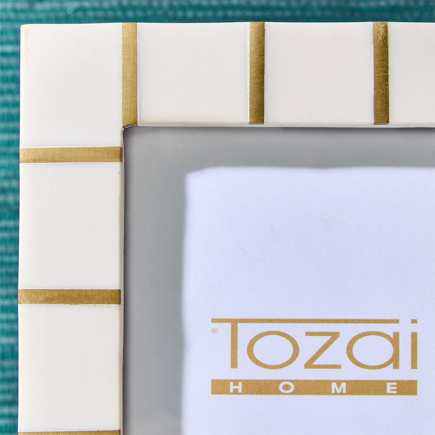 Decorative frame with gold stripes and 'Tozai Home' branding on a teal background