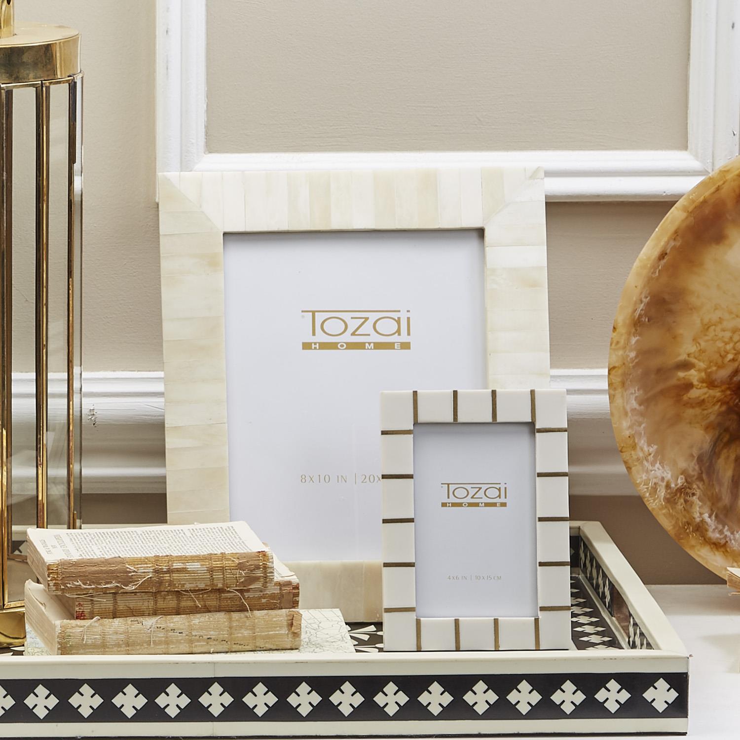 Decorative picture frames with 'Tozai' branding on a stylish surface.