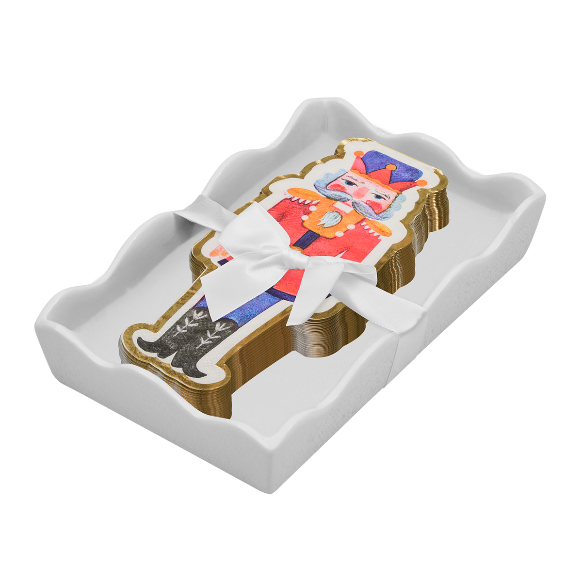 A stack of nutcracker-shaped napkins  wrapped in a white ribbon, presented in a white scalloped tray against a white background.