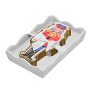 A stack of nutcracker-shaped napkins  wrapped in a white ribbon, presented in a white scalloped tray against a white background.