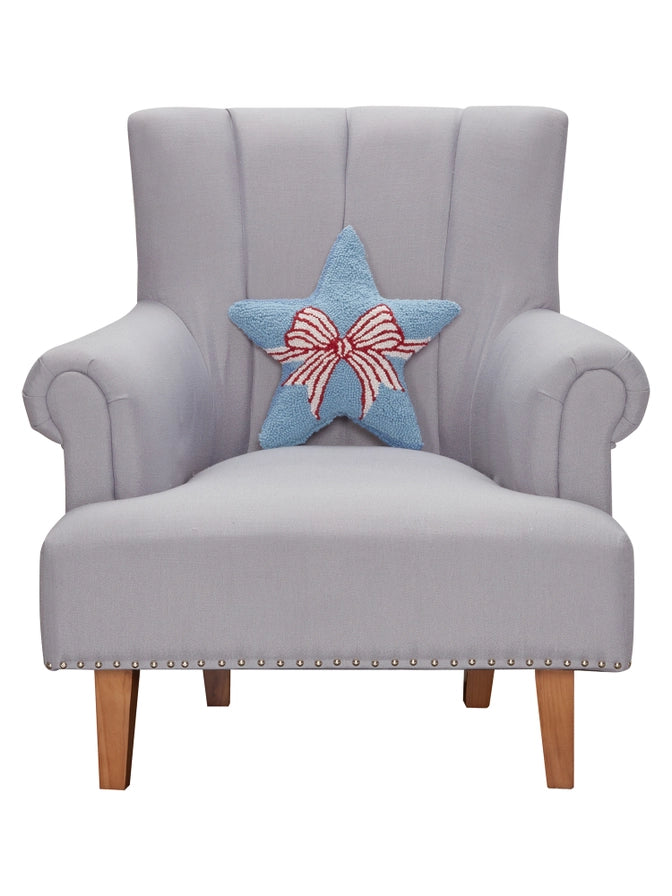 Gray armchair with a decorative blue pillow featuring a red bow on a white background