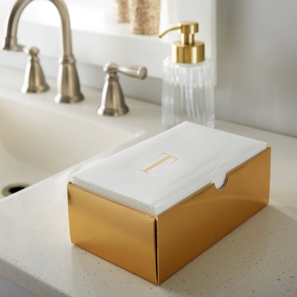 Party Luxe Brand Guest napkins in a gold box with letter gold T monogram on a kitchen counter