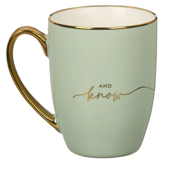 A mint green ceramic mug with a gold handle and rim, featuring the gold cursive text 'AND now' on the front, set against a plain white background.