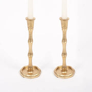 Two oak Lane brand gold bamboo shaped candle holders with white candles on a white background