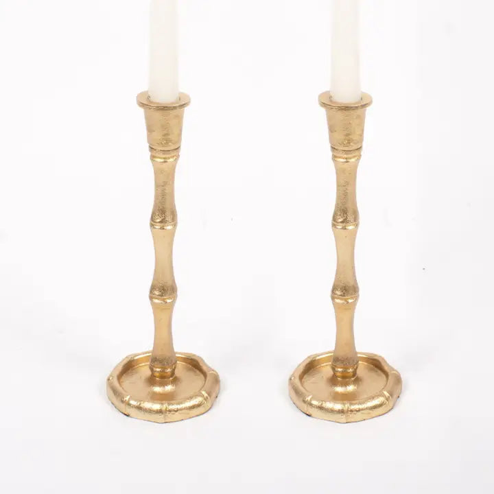 Two oak Lane brand gold bamboo shaped candle holders with white candles on a white background