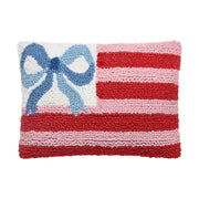 Decorative pillow with red and pink stripes and a blue bow on a white background