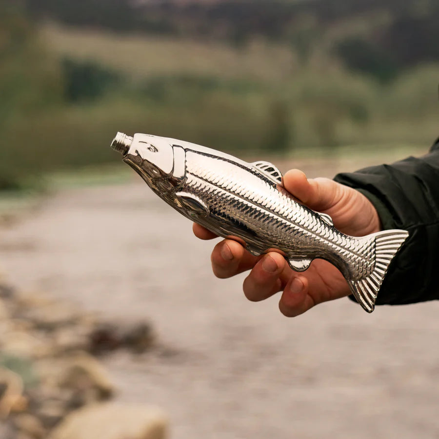 Stainless steel fish flask on white background being held by man on river