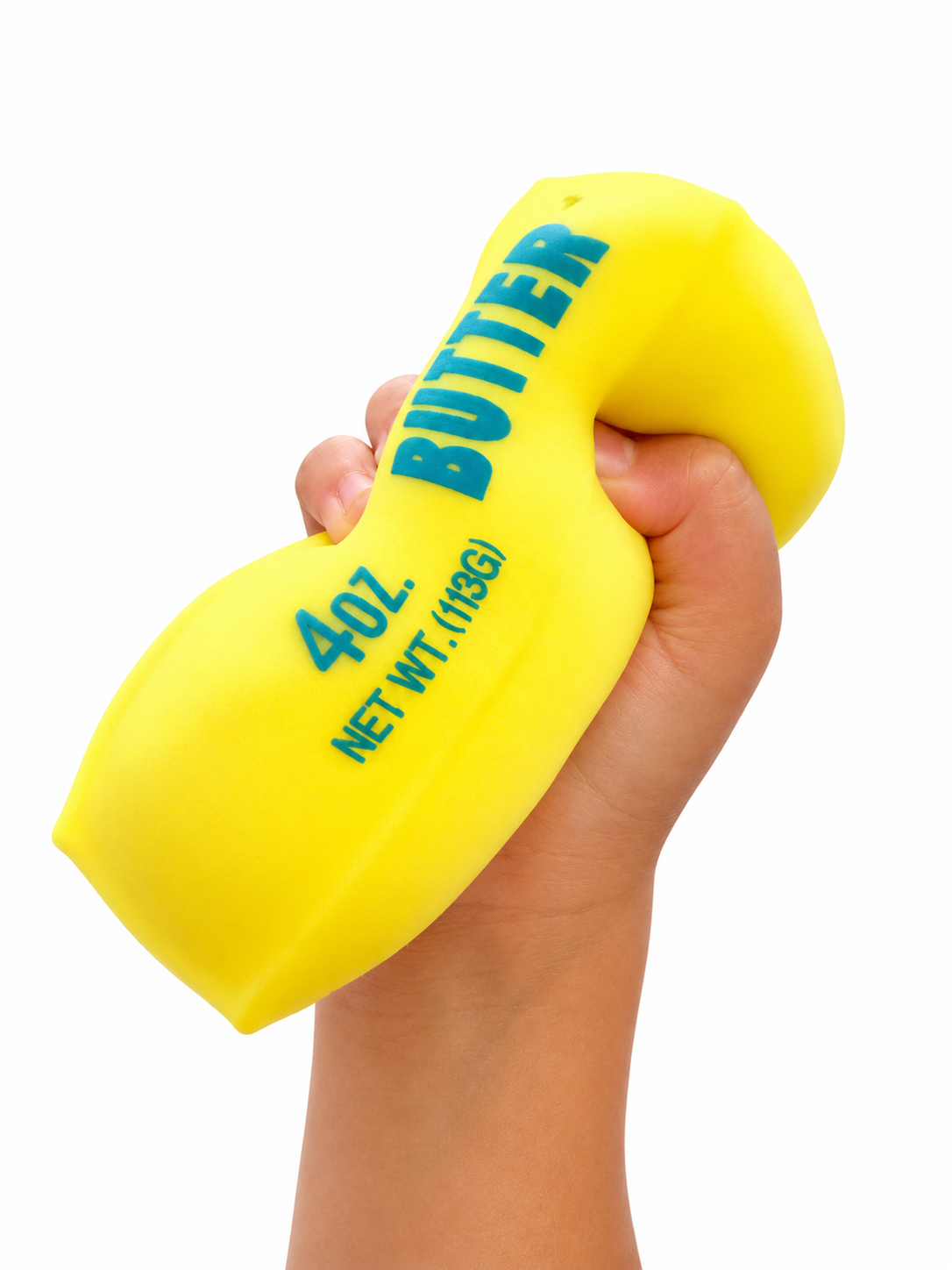 A hand squeezing a bright yellow novelty butter-shaped object with blue text reading 'BUTTER' and '4.0 OZ.