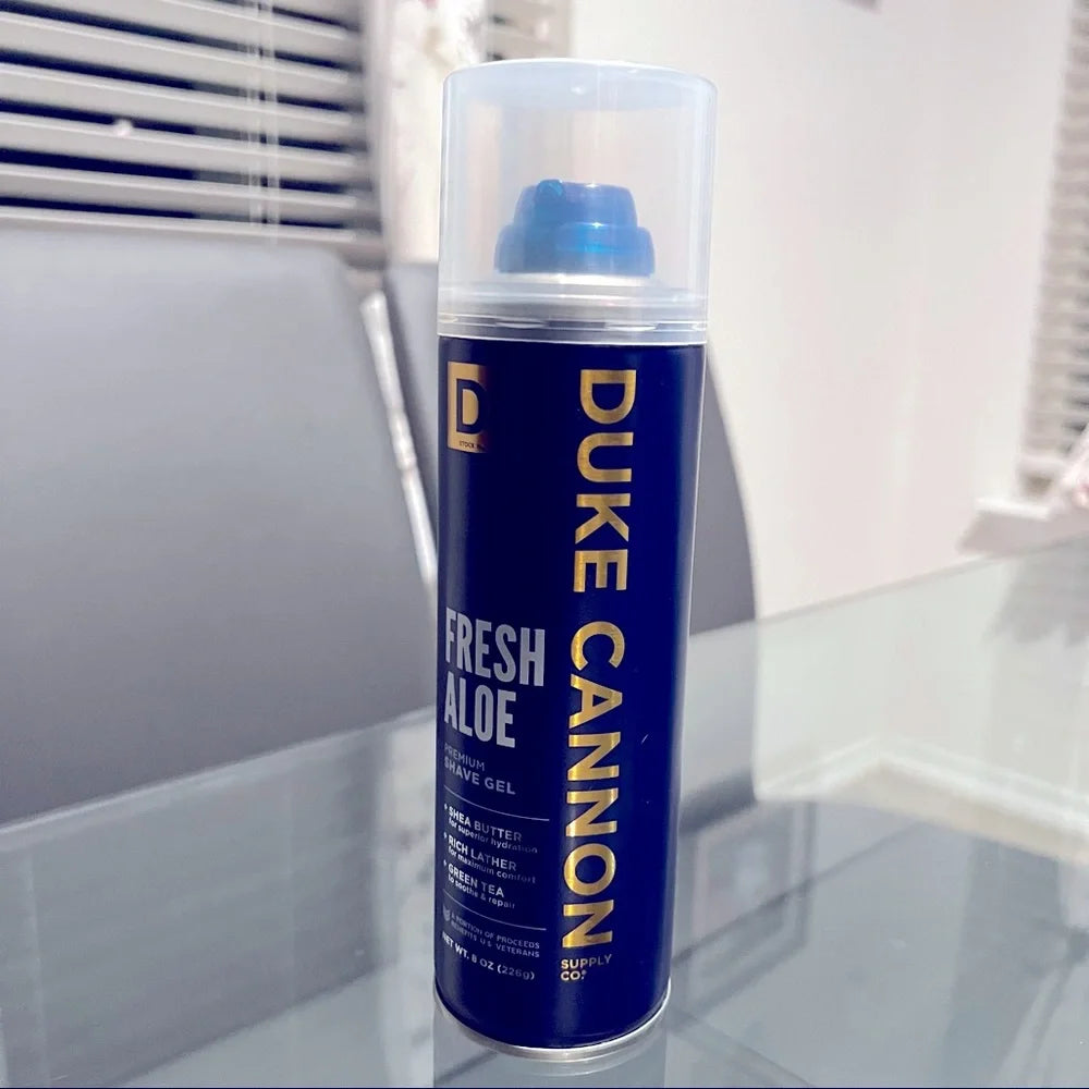 Blue can of Duke Cannon Fresh Aloe on a glass surface with a blurred background