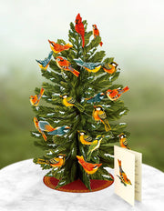 Decorative Freshcut Paper Brand Christmas tree with birds on a white surface and green background