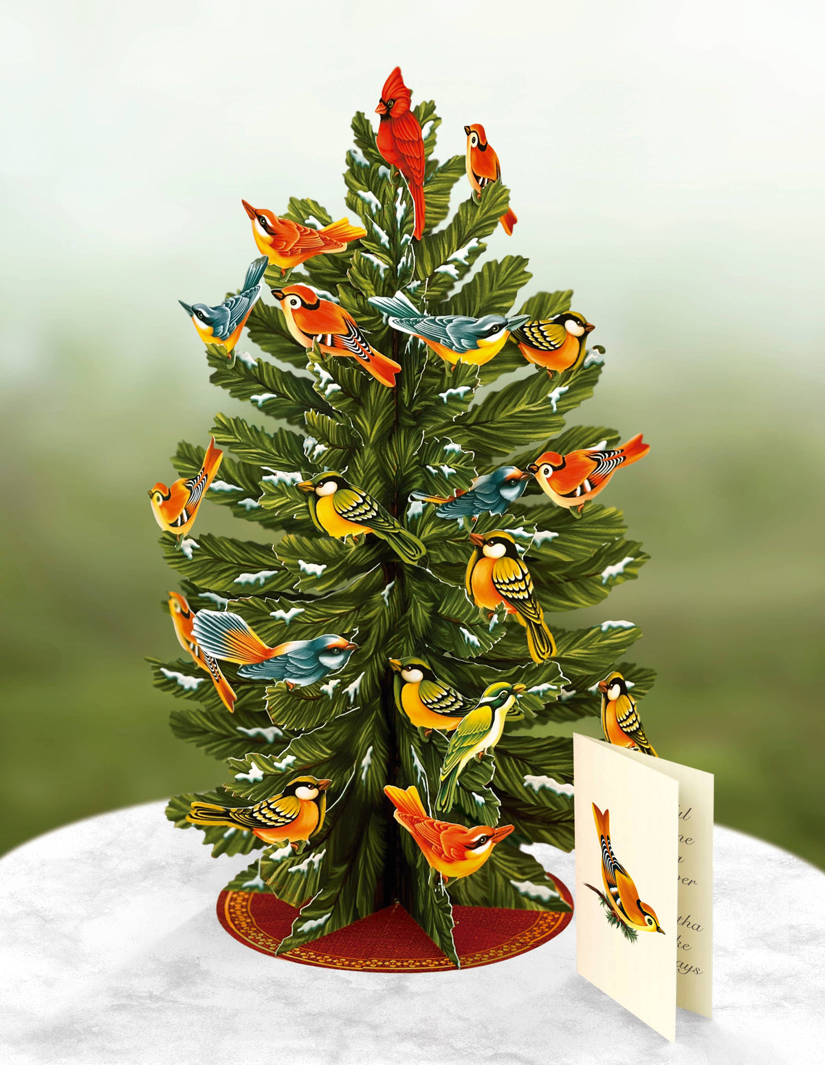 Decorative Freshcut Paper Brand Christmas tree with birds on a white surface and green background