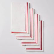 Four white paper napkins with red striped borders, arranged in a staggered stack on a light gray background.