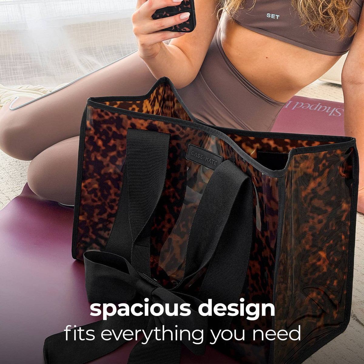 Person in background with a tortoise shell print tote bag with text 'spacious design fits everything you need'.