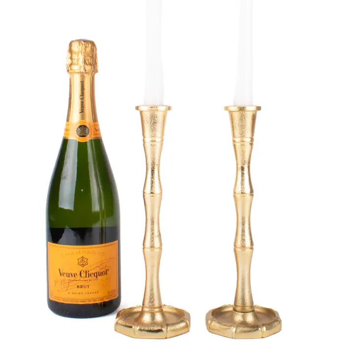 Veuve Clicquot champagne bottle with two 8 Oak Lane Brand gold bamboo shaped candle holders on a white background
