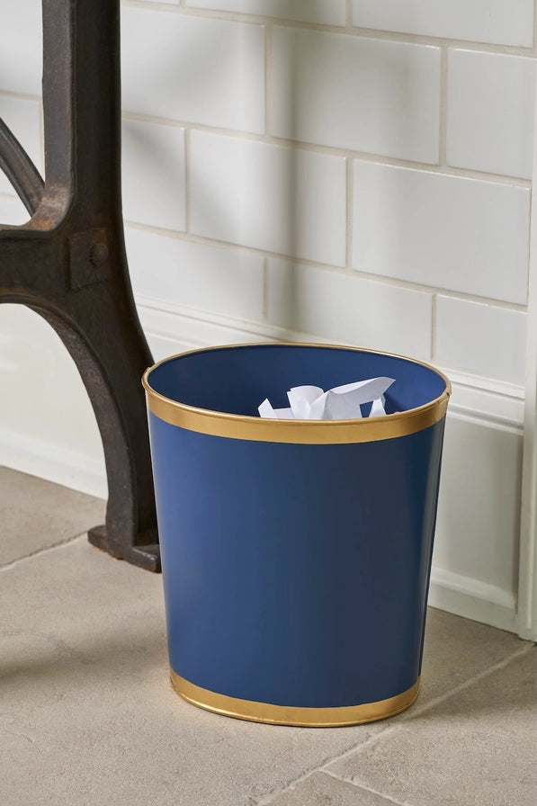 Blue trash bin with gold rim on a tiled floor