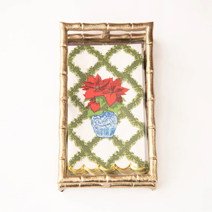 Decorative napkins with poinsettias and a lattice design in a gold holder.