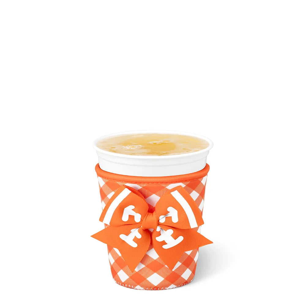 An orange and white gingham paper cup sleeve with a matching orange ribbon bow featuring white lettering, holding a white styrofoam cup with a yellow drink on a white background.
