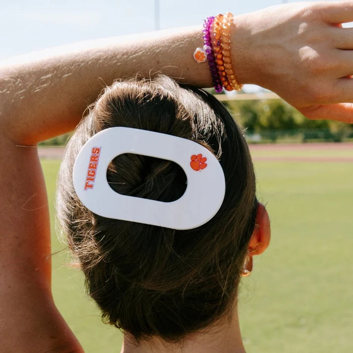 woman wearing white hairclip saying tigers