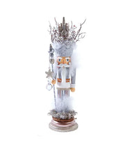 Decorative nutcracker figure with a white outfit and decorative hat on a white background