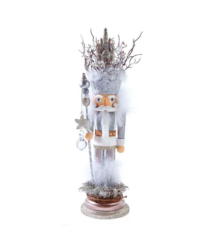 Decorative nutcracker figure with a white outfit and decorative hat on a white background