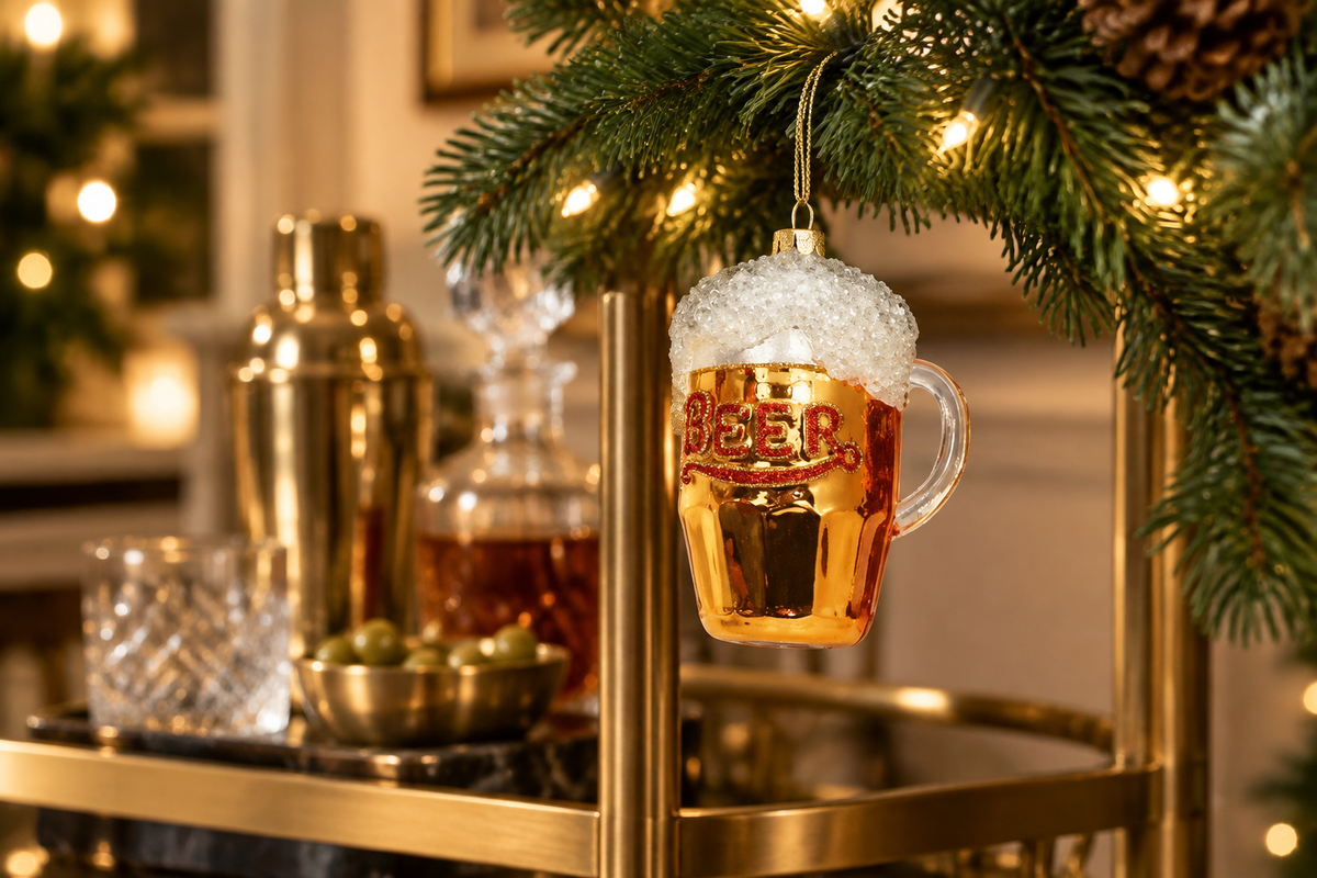 One Hundred 80 Degrees frothy beer mug ornament hanging beside a home bar cart with holiday garland