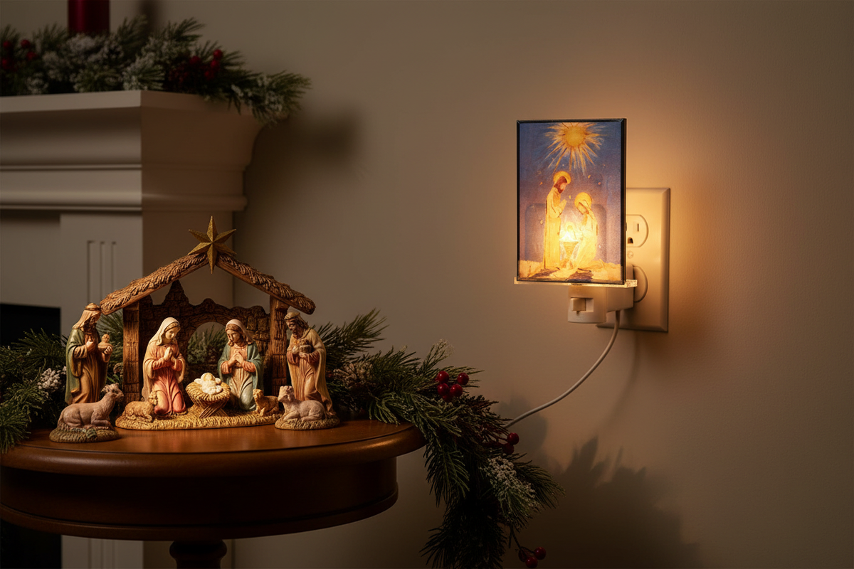 RAZ Imports 6-inch multicolor stained-glass Holy Family light illuminated beside a nativity display with its cord plugged into a wall outlet