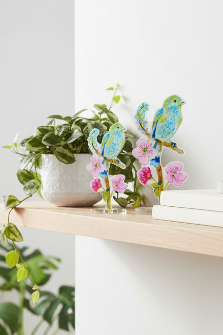 Home office with plants, books, and decorative items on a wooden shelf.